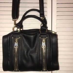 Black purse with faux zippers and detachable strap